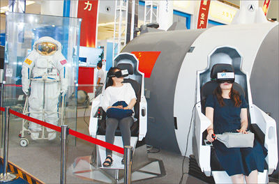 圖為參觀者通過VR（虛擬現(xiàn)實）設備體驗宇航員出艙的過程。